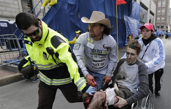 Carlos Arredondo helps a victim of the Boston Marathon bombings on Monday. Photo:  Charles Krupa / AP