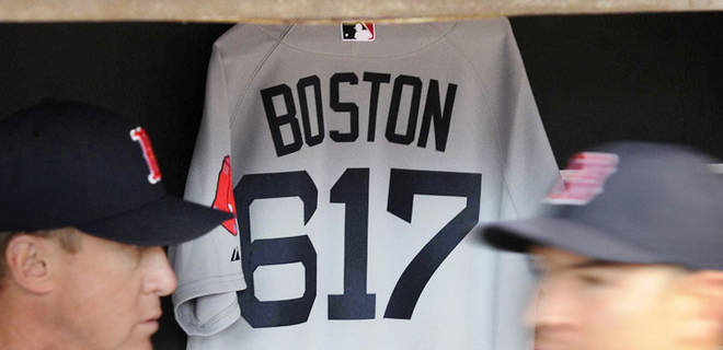 "Boston Strong" jersey, with that city's 617 area code, hangs in the Red Sox dugout Tuesday.