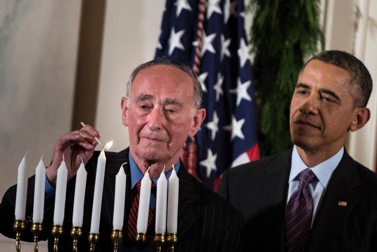 US President Barack Obama watches as Martin Weiss, a Holocaust survivor,  lights a Menorah during a Hanukkah reception in the Grand Foyer of the White House December 5, 2013. (AFP Photo/Brendan Smialowski)