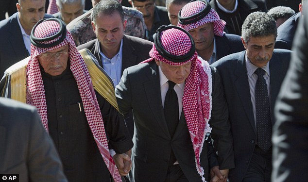 The tribute came as Jordan's King Abdullah II (centre) visited Moaz al-Kasasbeh's grieving family including his father, Saif (left) - in Aya village and one day after he vowed to wage a 'harsh' war against the militants 